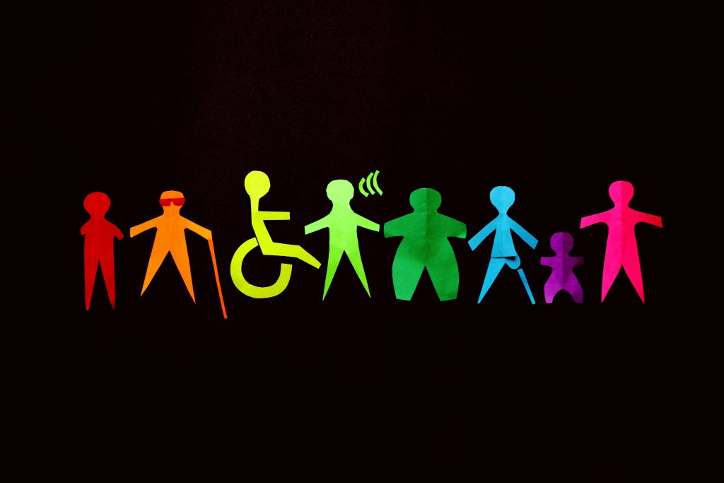 Des silhouettes vibrantes en papier découpé, représentant des figures diverses sur un fond noir, célèbrent l'inclusion et la diversité