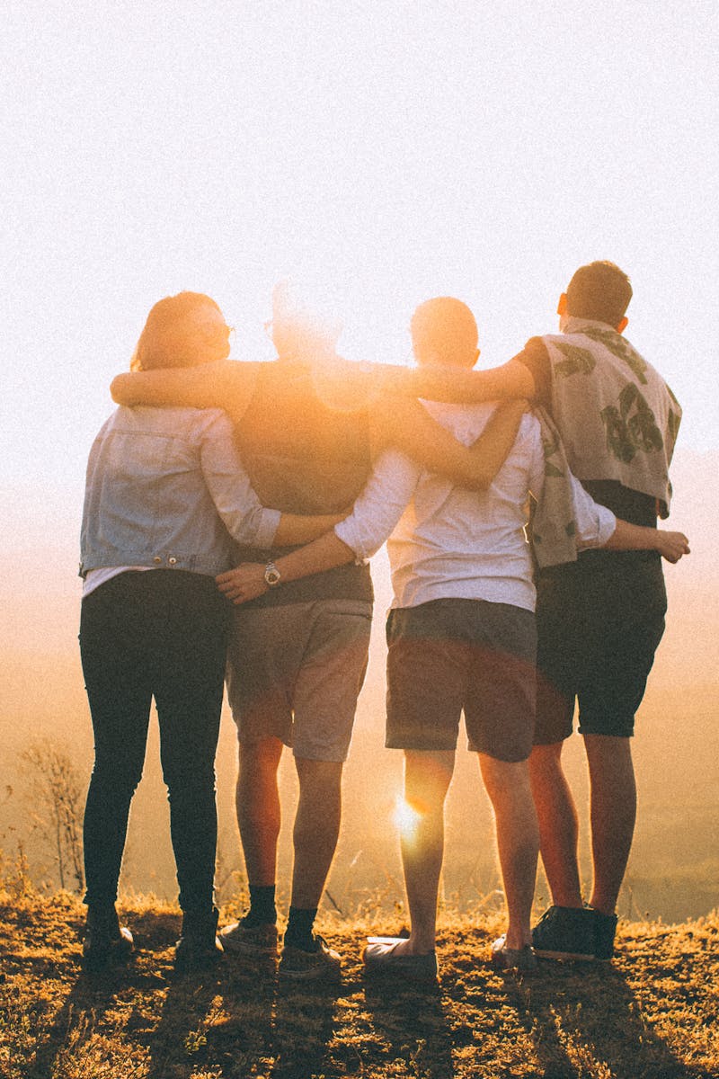 A group of friends embrace while enjoying a breathtaking sunrise over the Brazilian highlands.